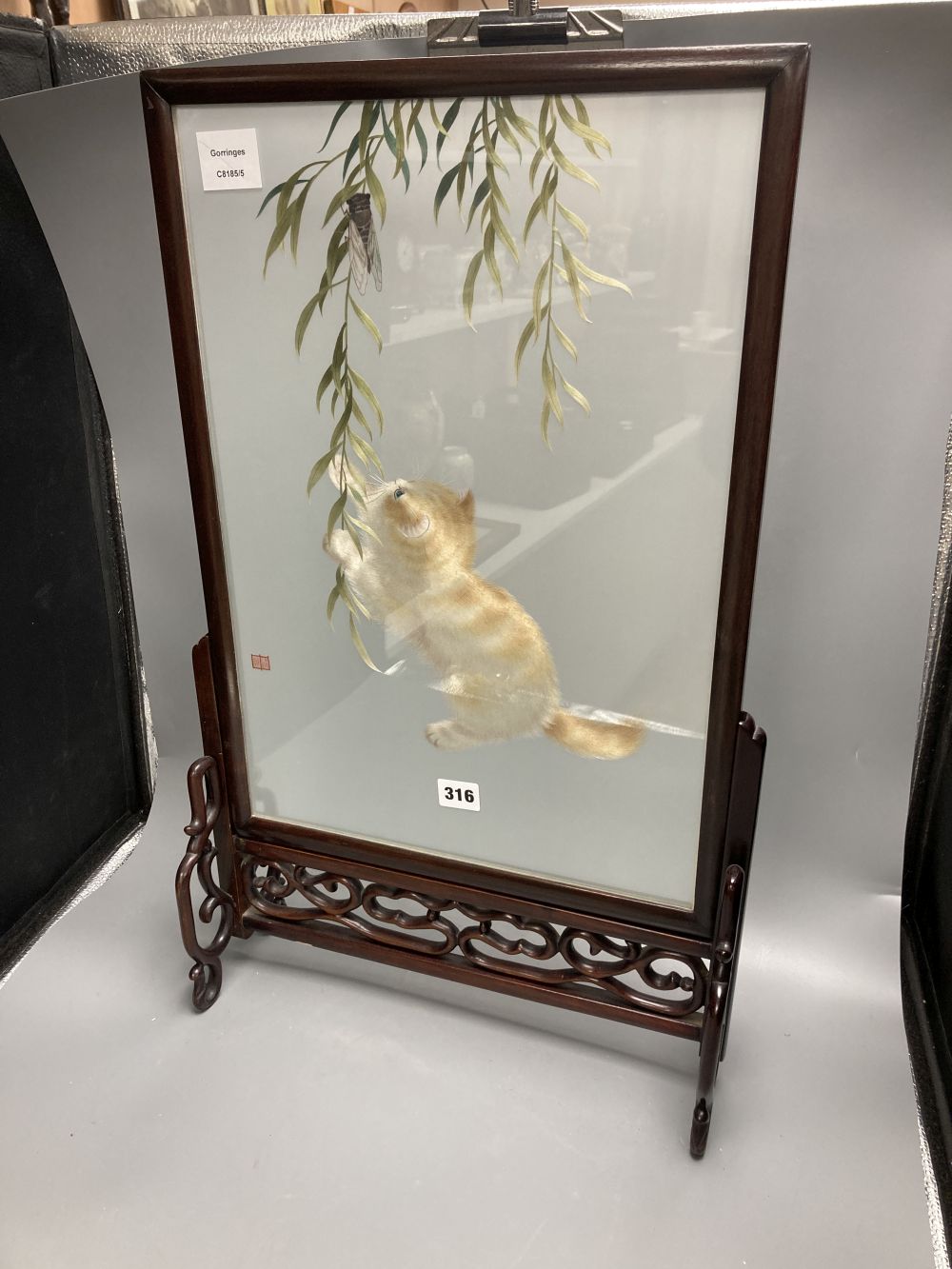 A Chinese carved hardwood framed table screen, the panel silk embroidered with a kitten at play, 66.5 x 40cm